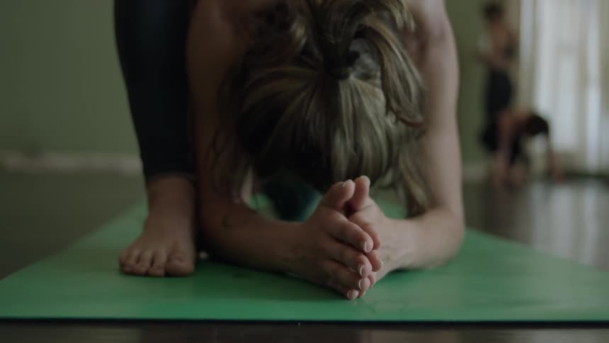 A woman does yoga in a yoga class