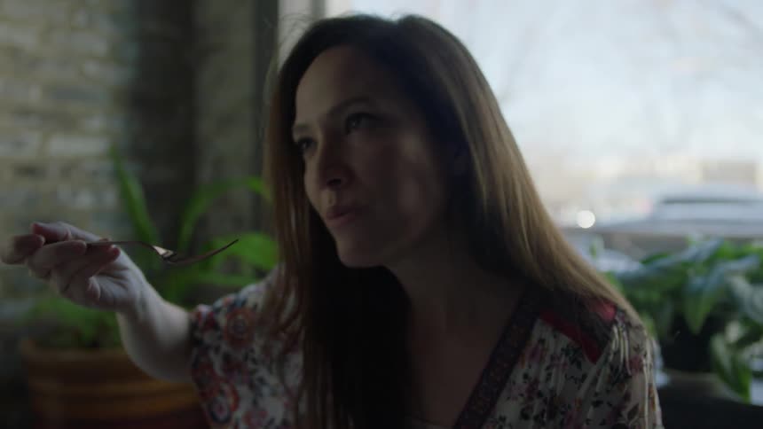 A woman tastes some food and talks