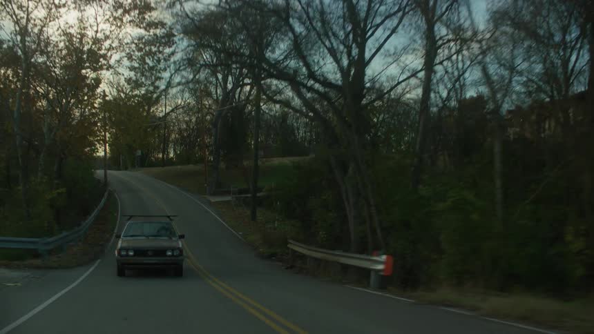 Car travels down the road under a blue sky