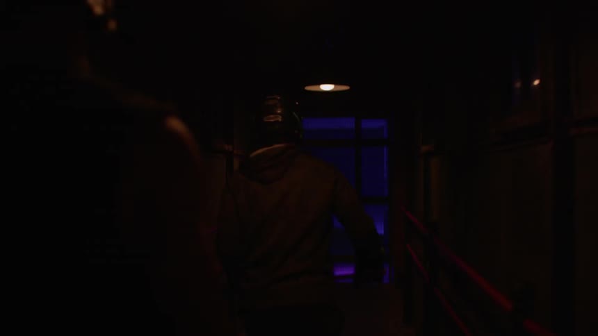 People wearing helmets walk down a hallway
