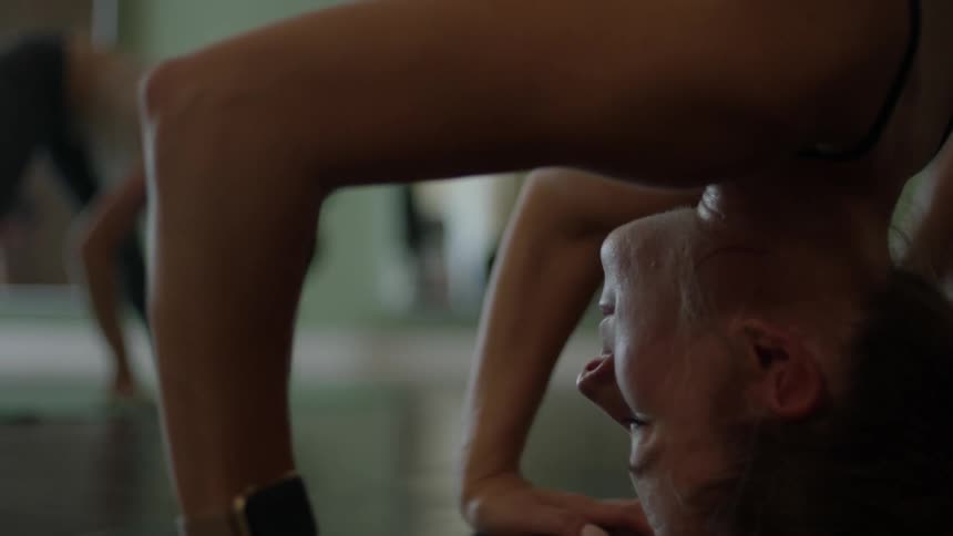 A woman balances on her head while doing a yoga pose