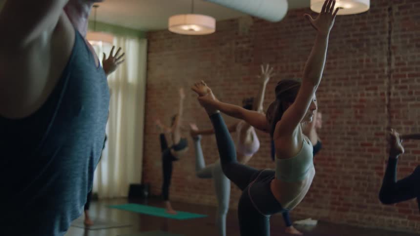 Men and women hold a yoga pose