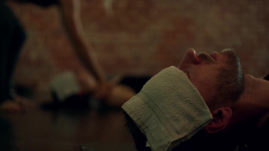 A man lies on the ground with a cloth on his forehead