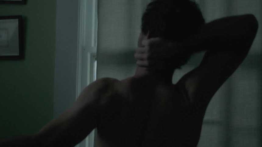 A man stretches waking up in his home