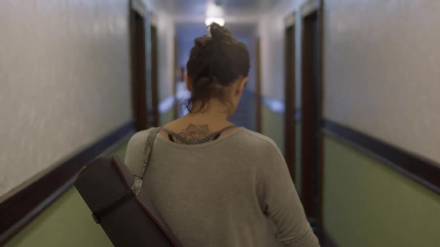 A woman pushes her bike through a hallway