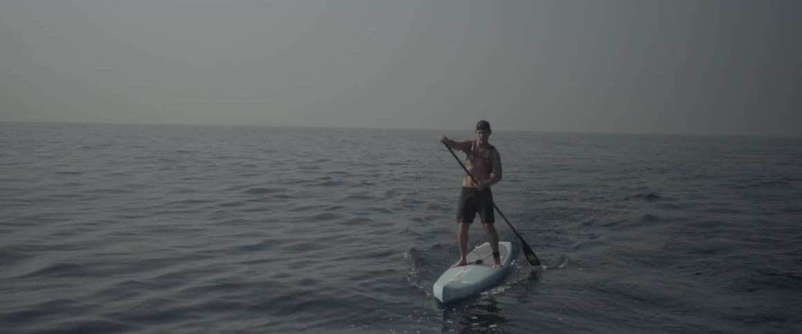 A man paddleboards on the ocean