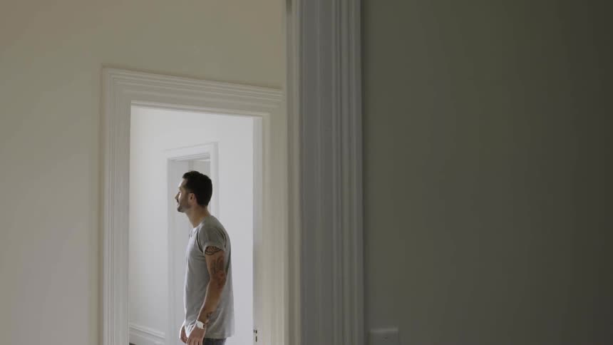 A man stands under a doorway