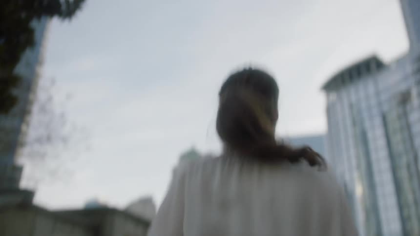 A woman smiles as she walks up steps to a field