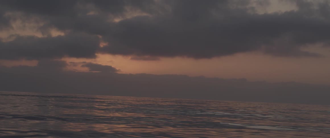 The sun is setting over the large body of water