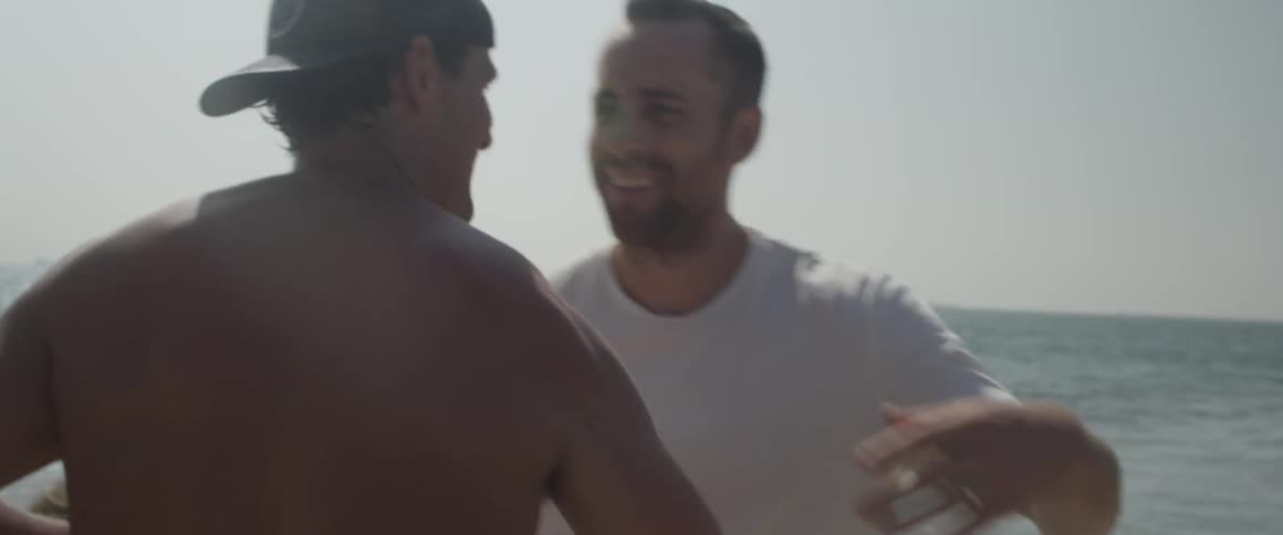 Men hug on a sunny beach