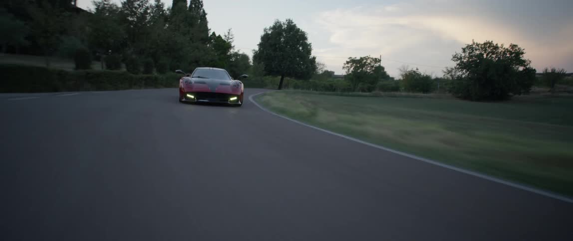 A sports car speeds along a country road