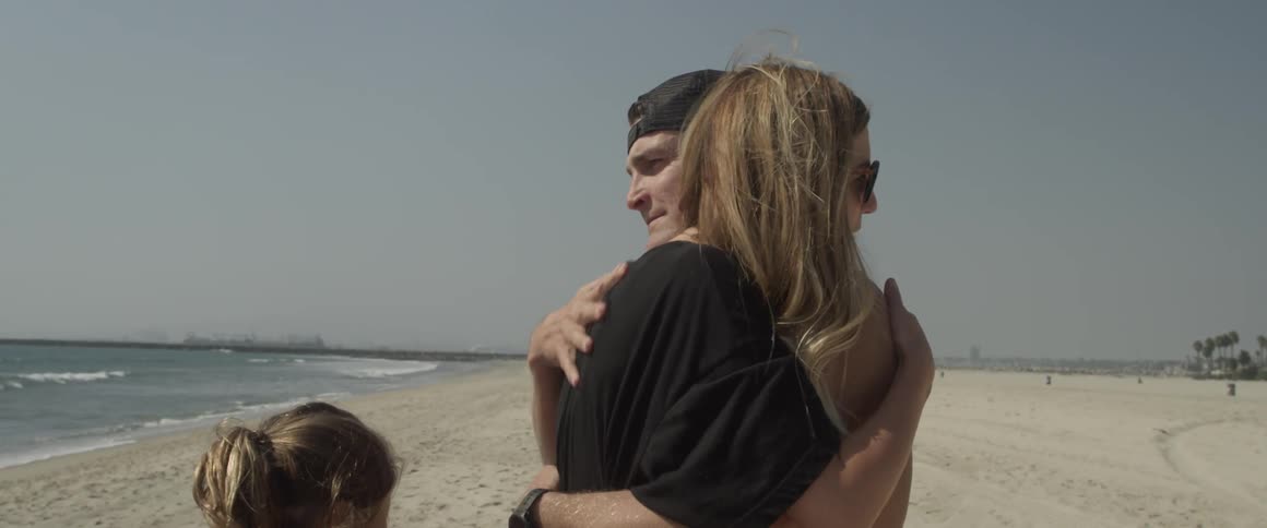 A man and woman hug on the beach