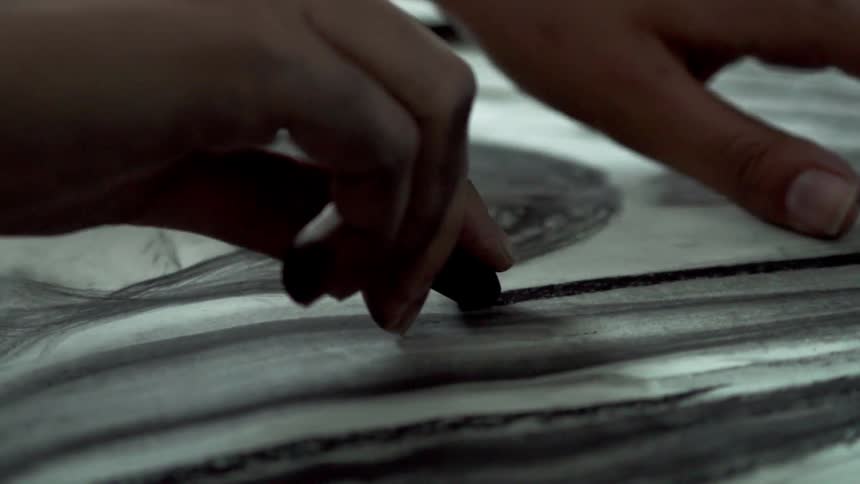 A person is creating art with charcoal