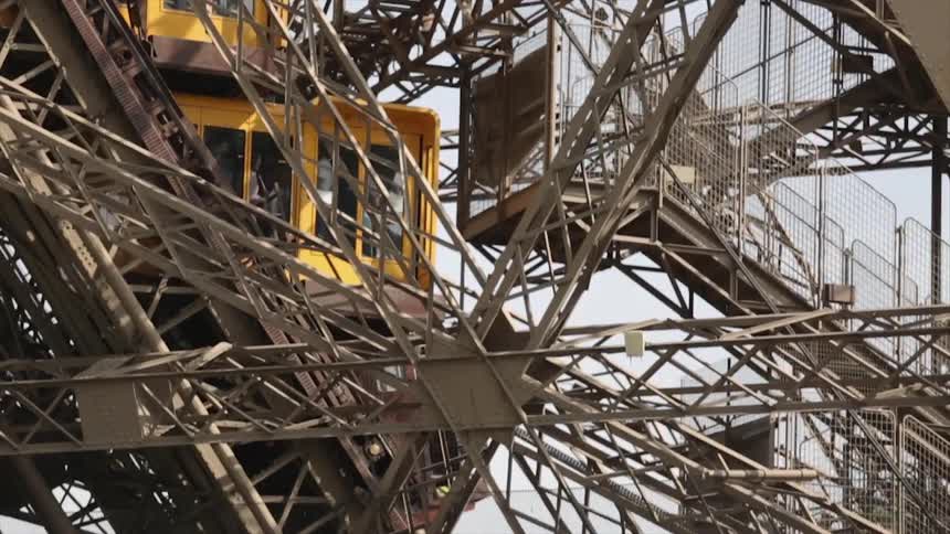 An elevator moves down the metal structure