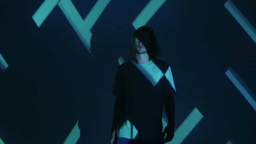 A man walks through a room with flashing blue lights