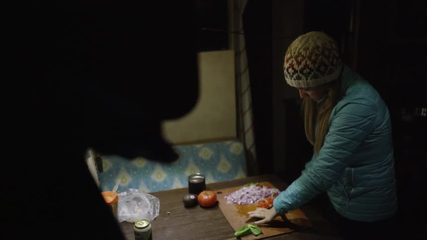A woman cuts vegetables on a cutting board