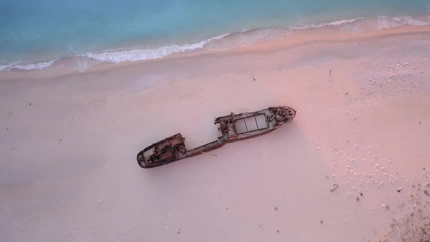A rusted broken boat on a beach