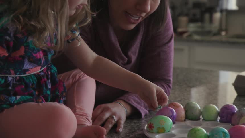A child puts stickers on some easter eggs