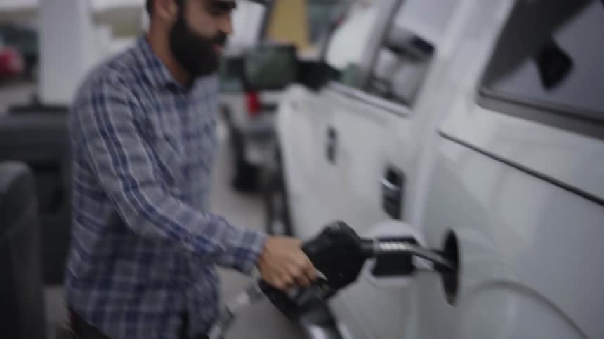 A man pumps gas into a truck