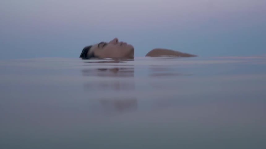A woman floats in the ocean
