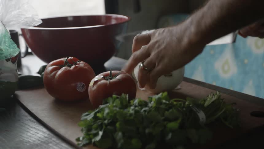 A man cuts vegetables on a cutting board