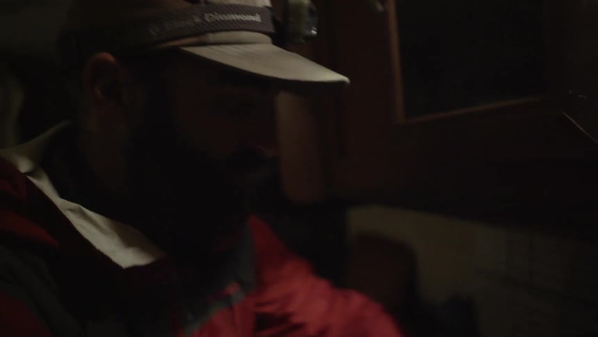 A man is working on something in a dark room