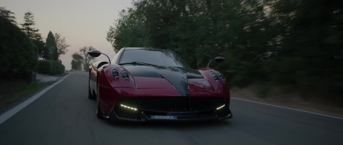 A sports car is racing down the small road
