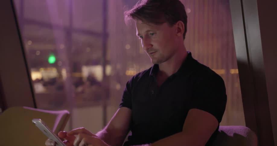 A man sits down and swipes on his phone