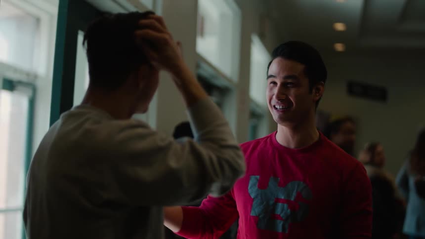 Two men talking just inside a door