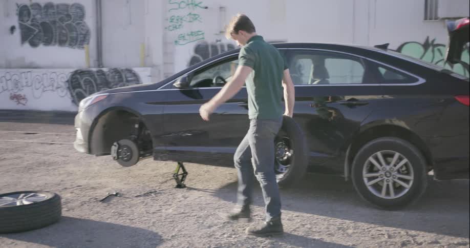 A man changes a flat tire
