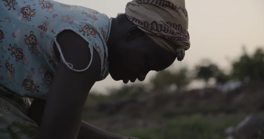 A woman works outside in a rural field
