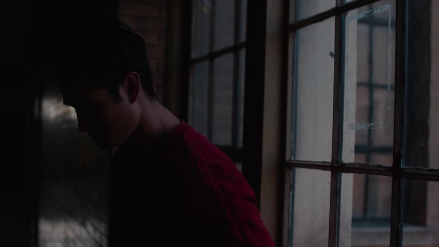 A man leans against a window
