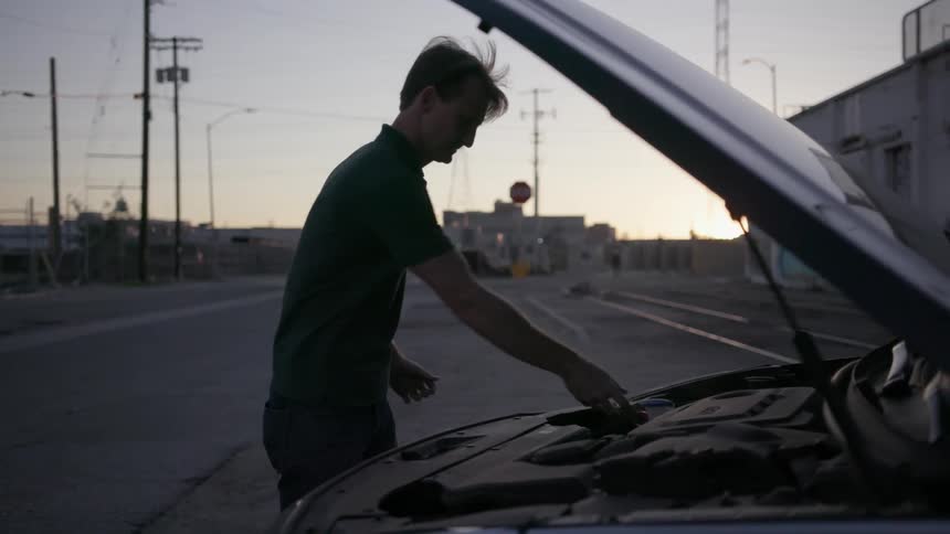 A man is examining his car engine