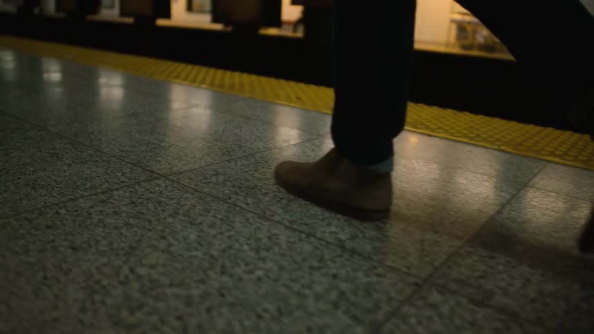 A person walks the platform at a subway station