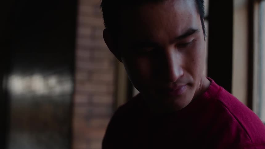 Man in a red shirt blinks his eyes