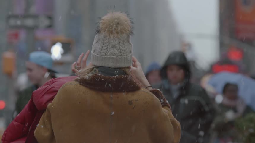 A woman gestures while looking at her phone