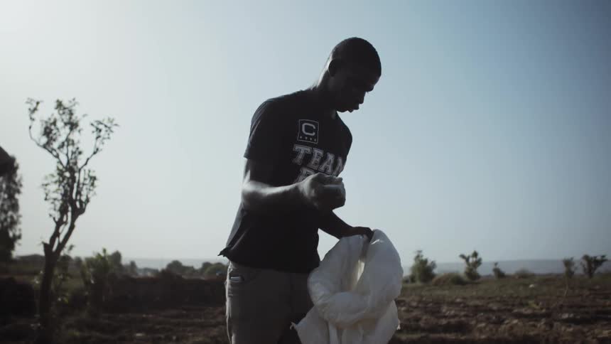 A man tosses fertilizer onto a farm field