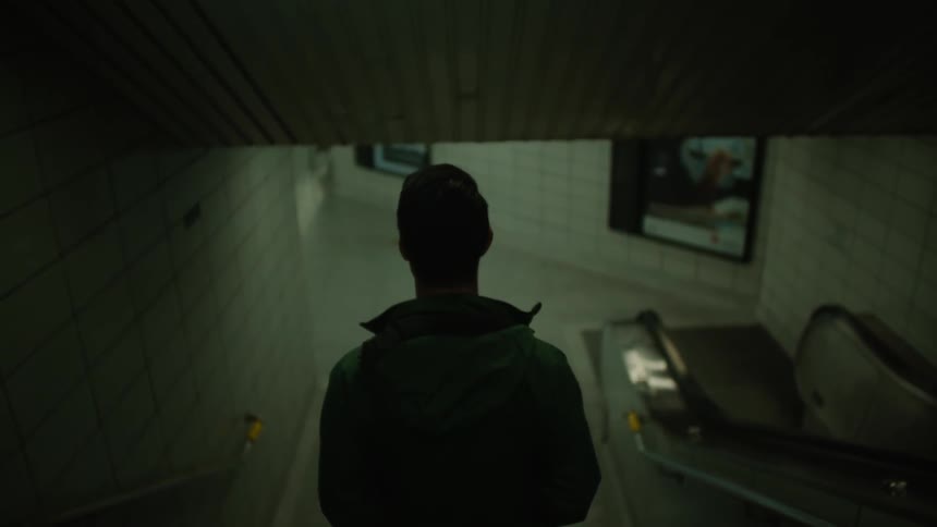 A man in a green jacket walks down some stairs