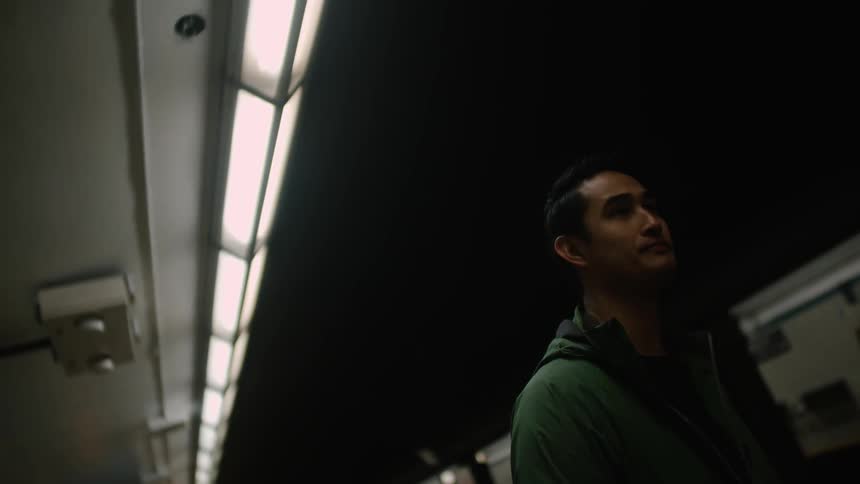 A man waits for a subway train inside a station