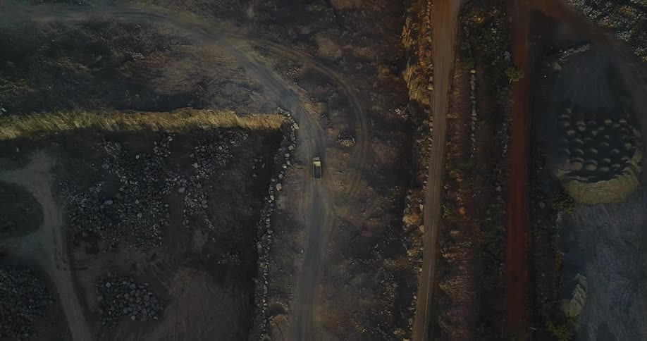 A truck drives on a dirt road