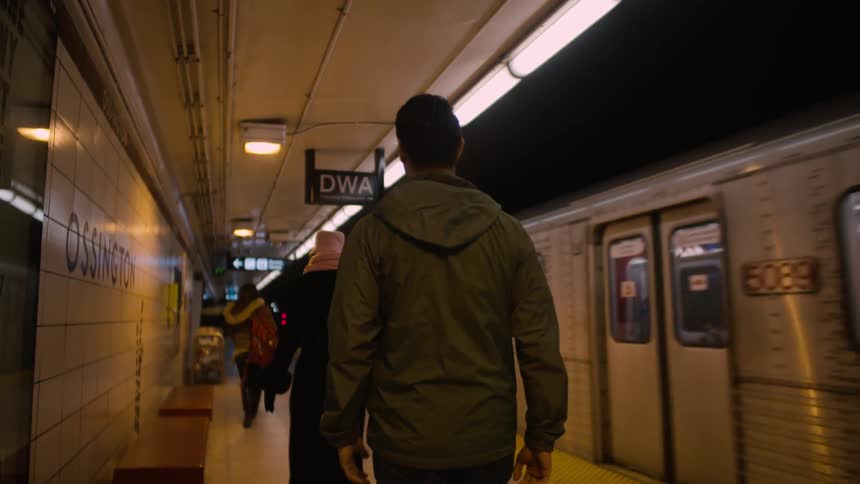 People walking in subway as train passes by