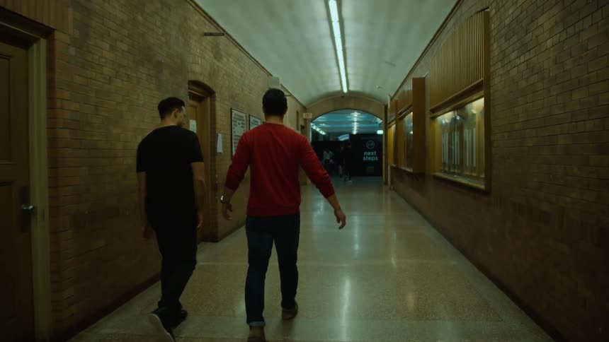 Two men shake hands and walk down the hall