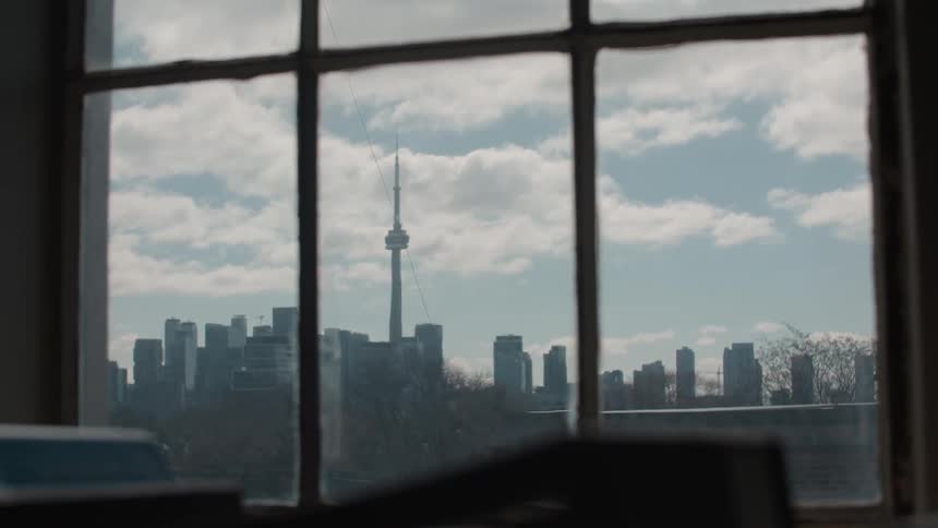 View looking out a window at tall skyscrapers in a city