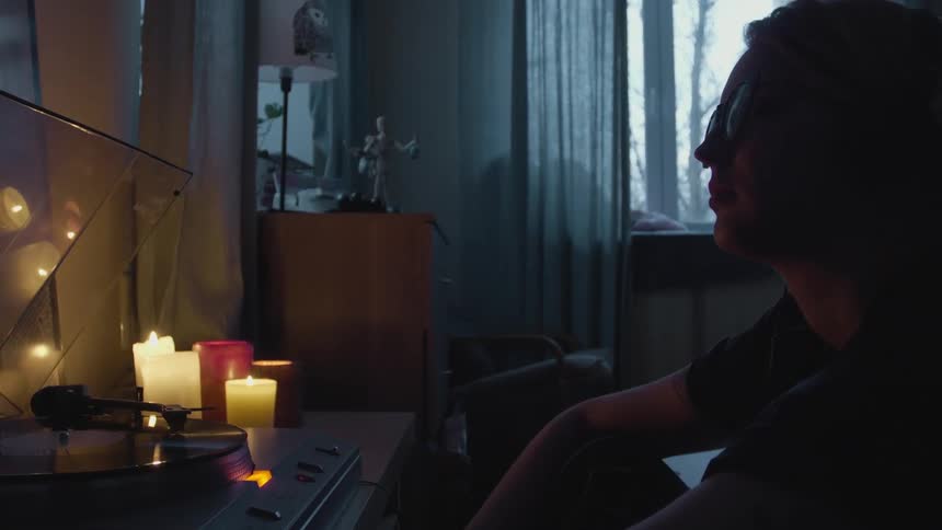 A woman is sitting in front of a record player