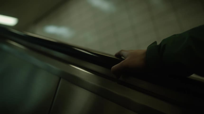 Person riding escalator up out of subway