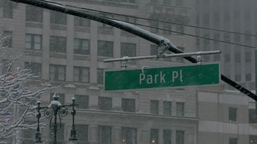 Close up of a street sign as snow falls