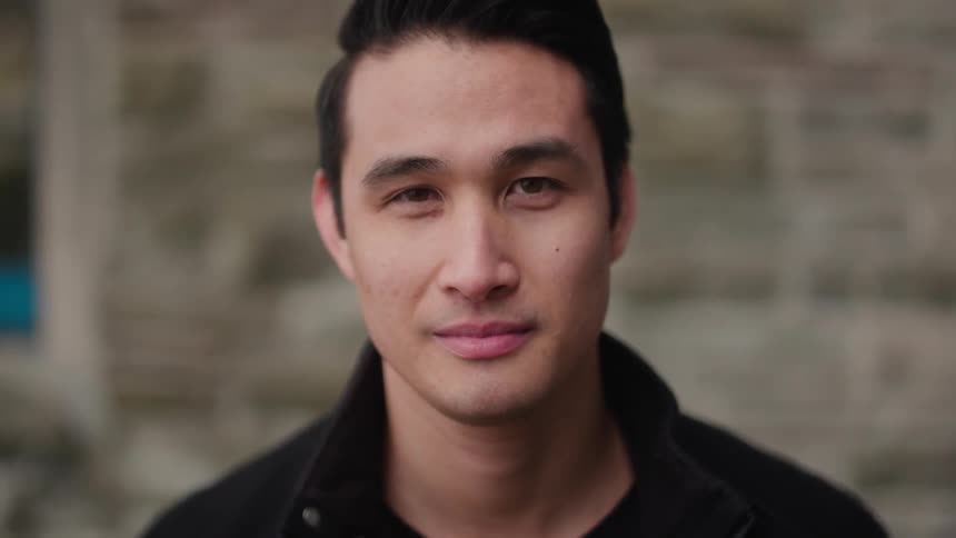 A man is smiling and looking forward