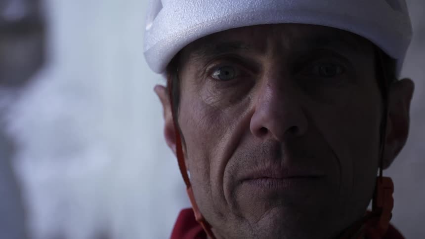 A man stands unmoving while wearing a helmet