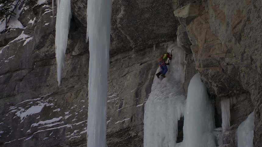A man is climbing an icy waterfall