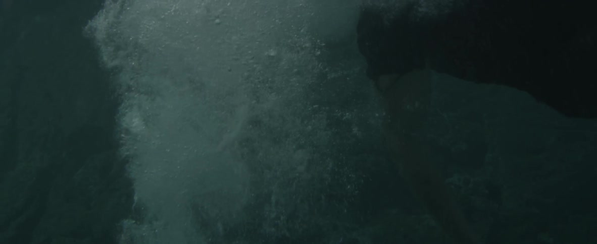 A man falls off a makeshift raft into the ocean